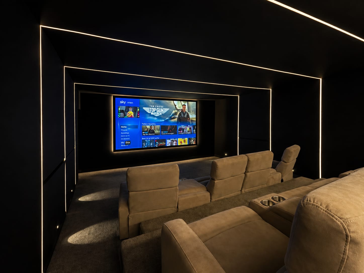 A dedicated cinema room with cream recliner seating and recessed linear lighting tracing the walls and ceiling