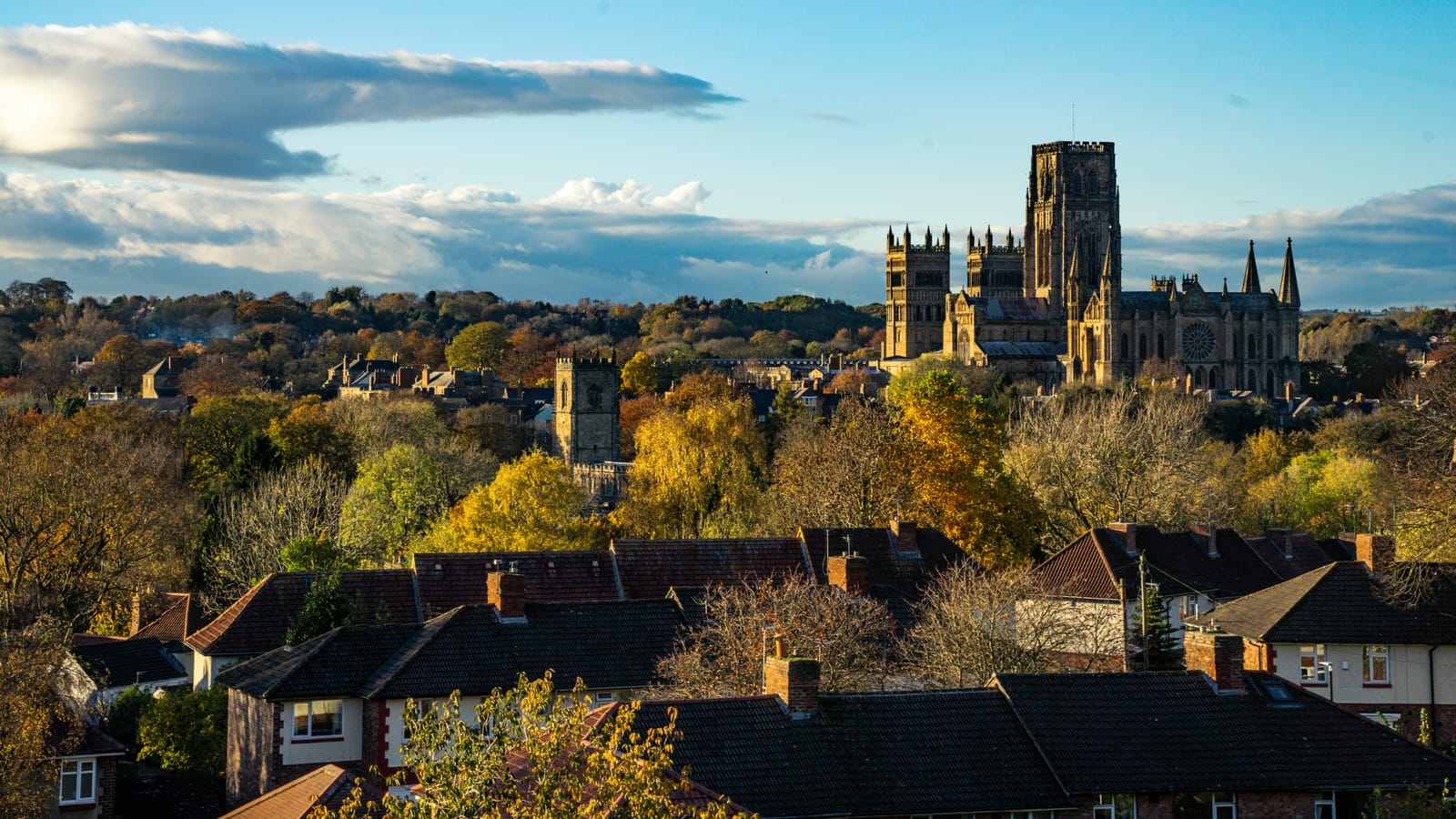 Durham Cathedral rising above autumn trees and the rooftops of the city