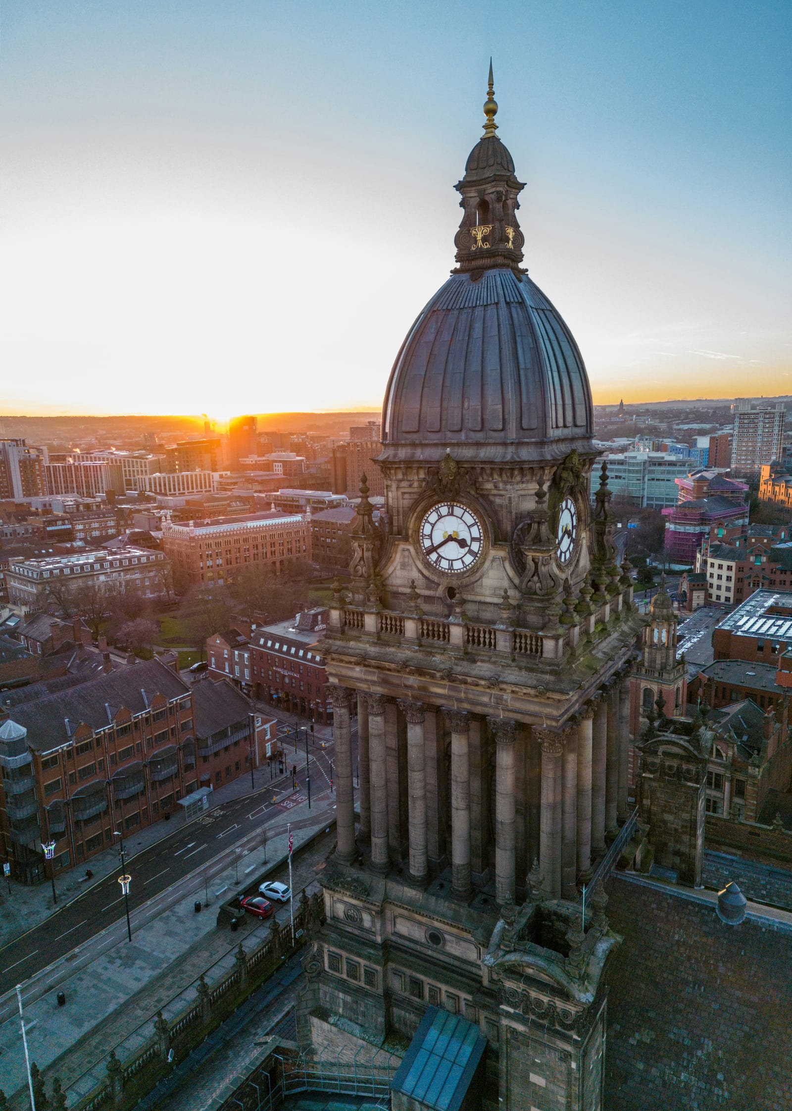 Leeds Town Hall's clock tower and dome at sunrise, the city spread out behind it