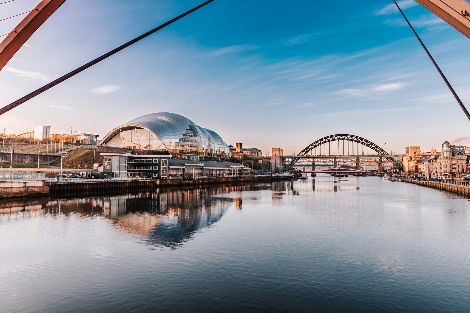 The Tyne at sunset, with the Sage, the Tyne Bridge and the quayside seen from the Millennium Bridge