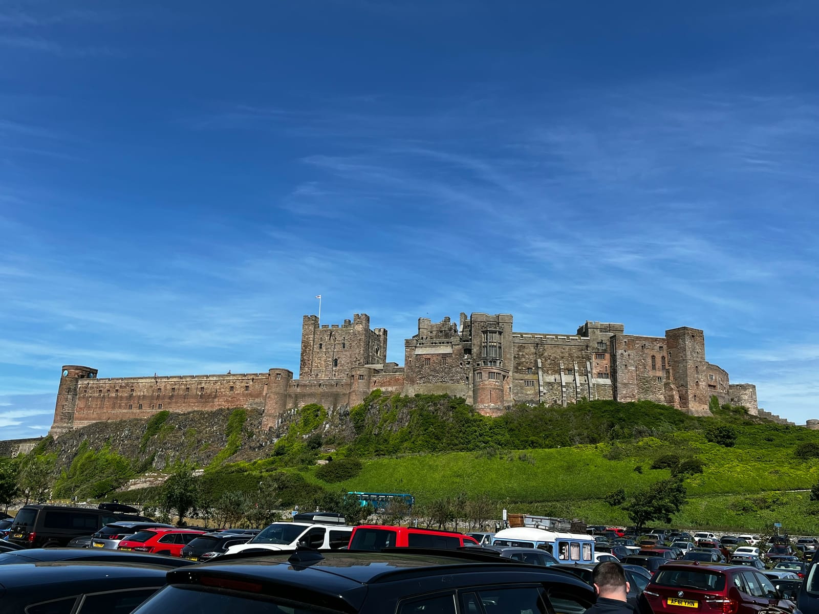 Bamburgh Castle on its rock above the dunes, under a wide blue sky