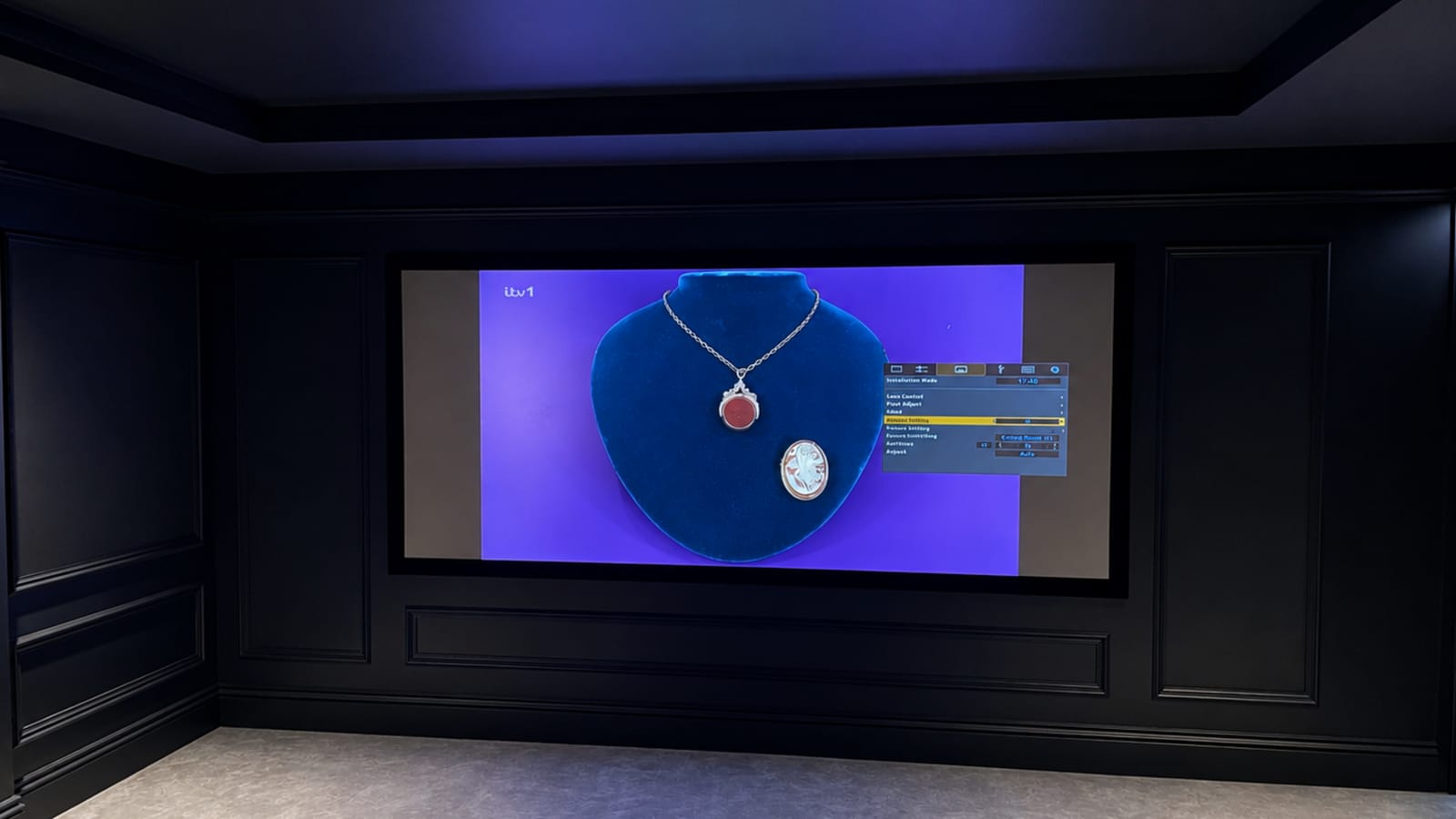 Video calibration for home cinema: the projector's colour management menu overlaid on a test image in a dark panelled cinema room